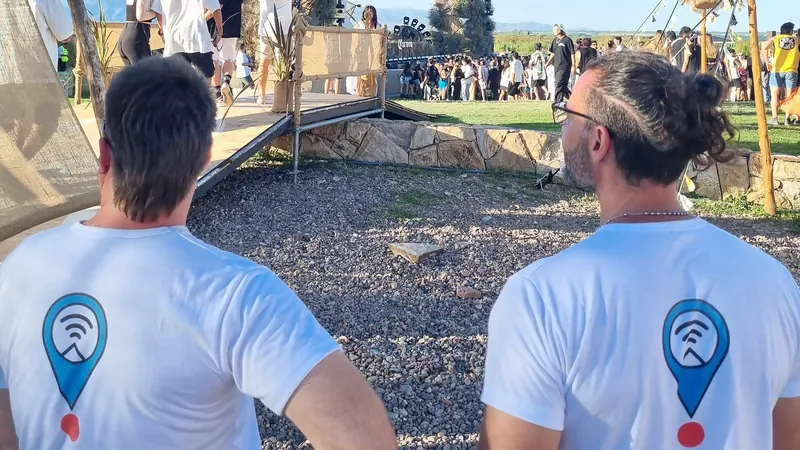 Equipo de Outdoor Office, de espaldas, siguiendo un festival al aire libre